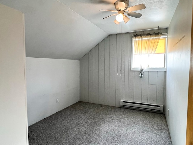 additional living space featuring carpet, vaulted ceiling, ceiling fan, and a baseboard heating unit