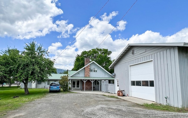 view of front of home with a garage, covered porch, and a front yard