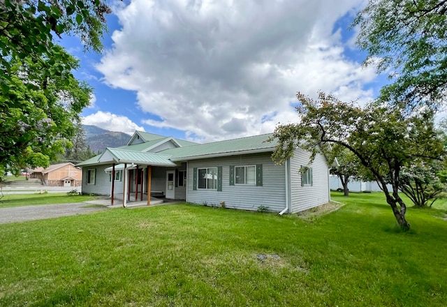 view of front of house featuring a mountain view, a porch, and a front lawn