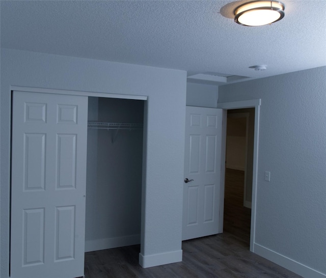 4019 Lancaster Rd, Missoula, MT 59808 - unfurnished bedroom with a textured ceiling, dark wood-type flooring, and a closet