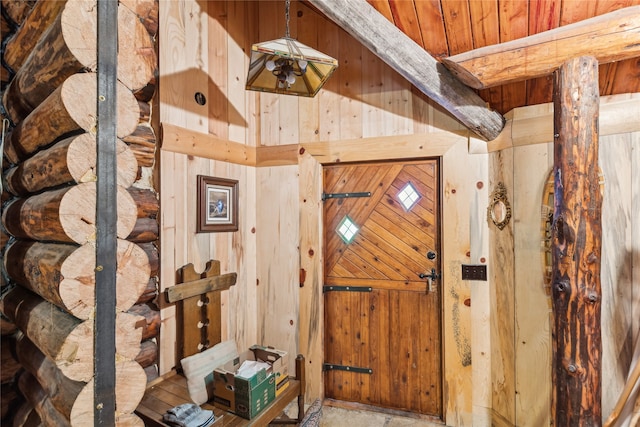 entrance foyer featuring wood ceiling and wooden walls