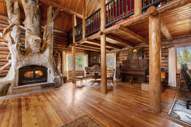 unfurnished living room with hardwood / wood-style floors, rustic walls, and wooden ceiling