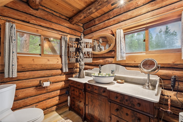 bathroom with beam ceiling, log walls, and wooden ceiling