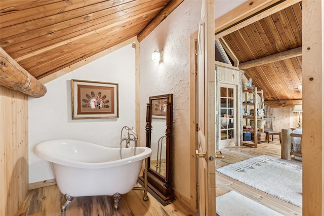 bathroom with hardwood / wood-style floors, lofted ceiling with beams, wooden ceiling, and a bathing tub