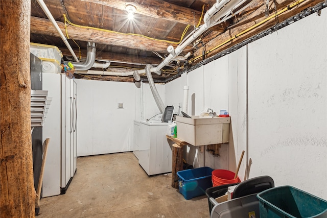 basement featuring washer and clothes dryer and sink