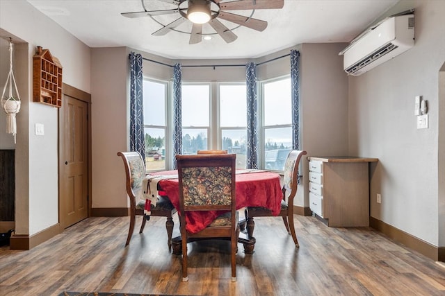 dining area with a wall unit AC, ceiling fan, and hardwood / wood-style flooring