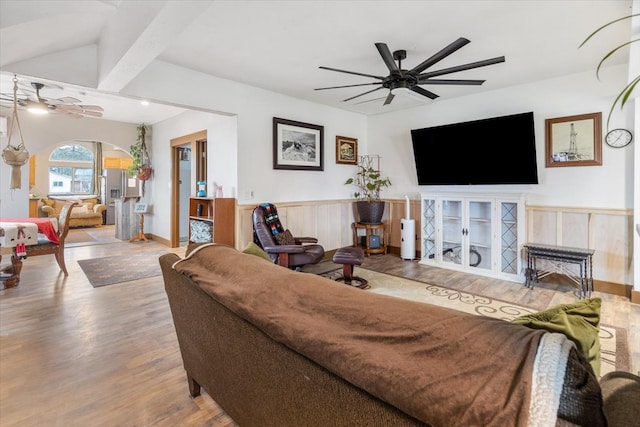 living room featuring hardwood / wood-style floors, vaulted ceiling with beams, and ceiling fan