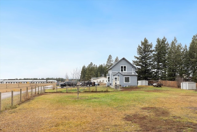 view of yard featuring a rural view and a storage shed