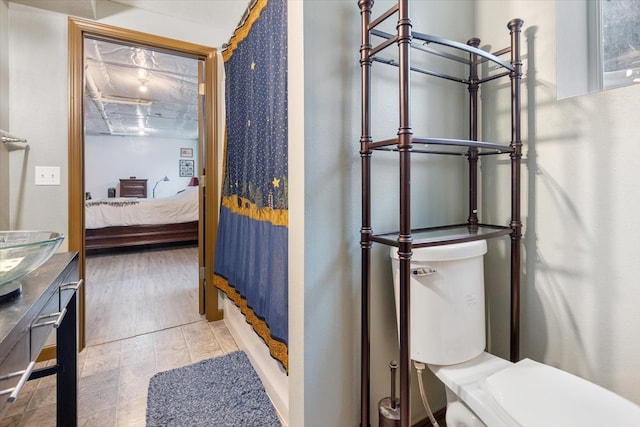 bathroom with toilet and wood-type flooring