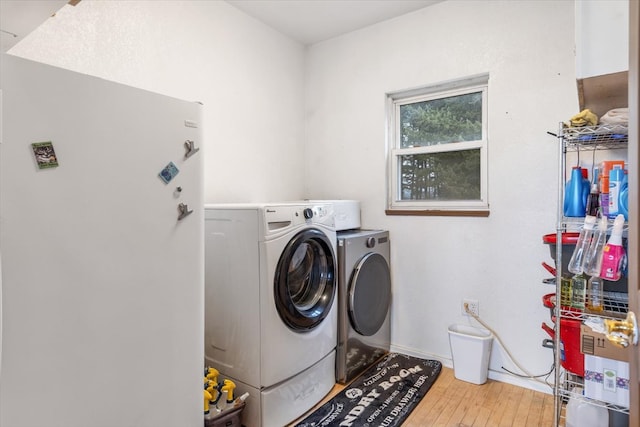 washroom featuring washing machine and clothes dryer and hardwood / wood-style floors