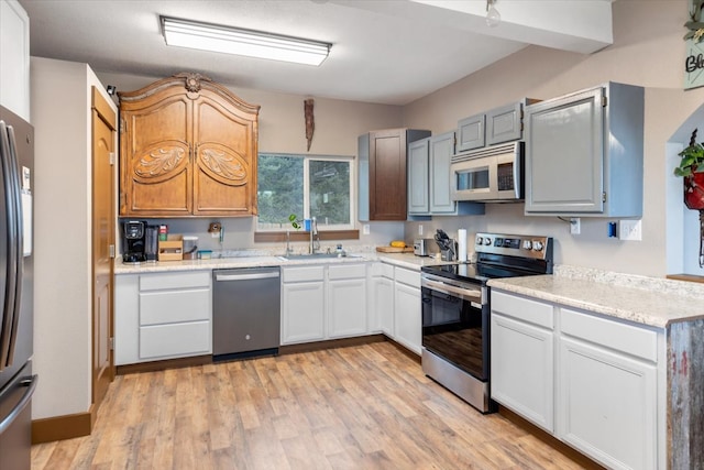 kitchen featuring sink, white cabinets, stainless steel appliances, and light hardwood / wood-style floors