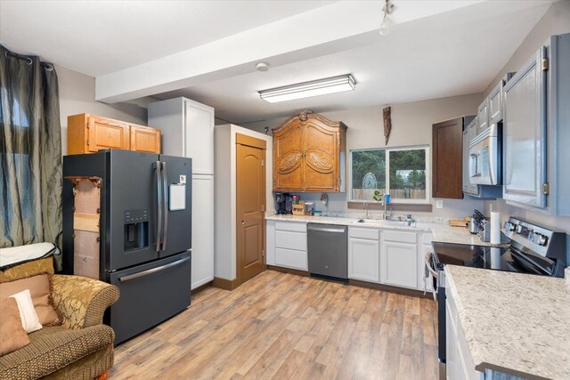 kitchen featuring white cabinetry, sink, light wood-type flooring, and appliances with stainless steel finishes