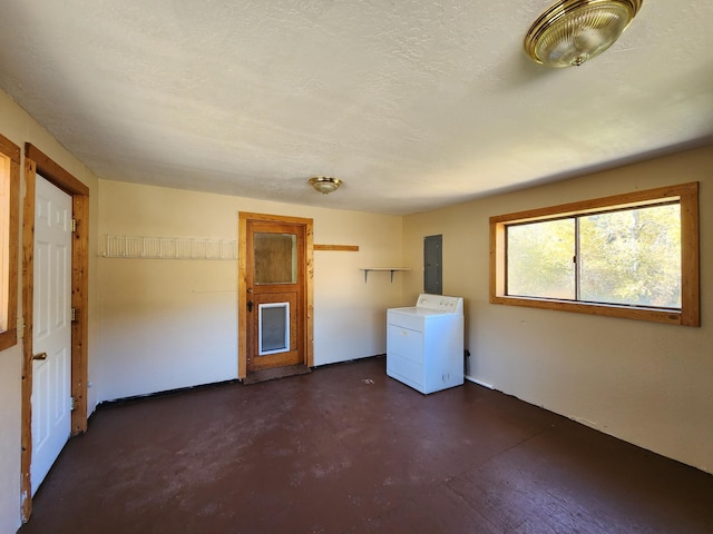 washroom featuring washer / dryer, a textured ceiling, and electric panel