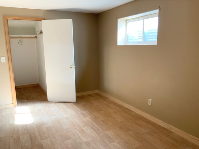 unfurnished bedroom featuring light wood-type flooring and a closet