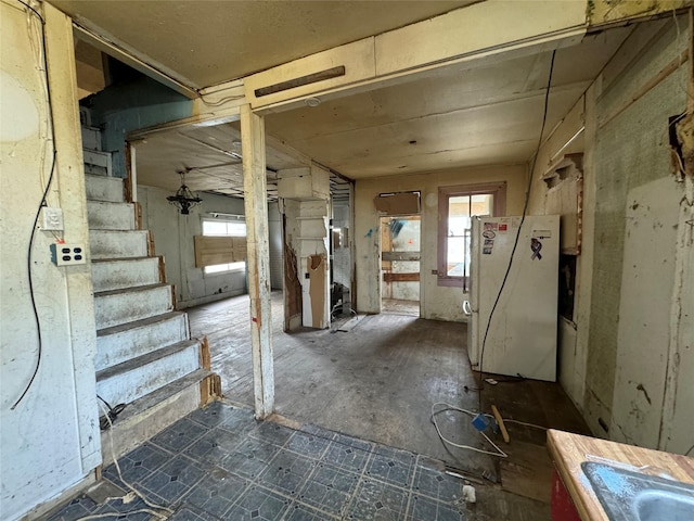 703 Birch St, Anaconda, MT 59711 - below grade area with freestanding refrigerator, plenty of natural light, and stairs