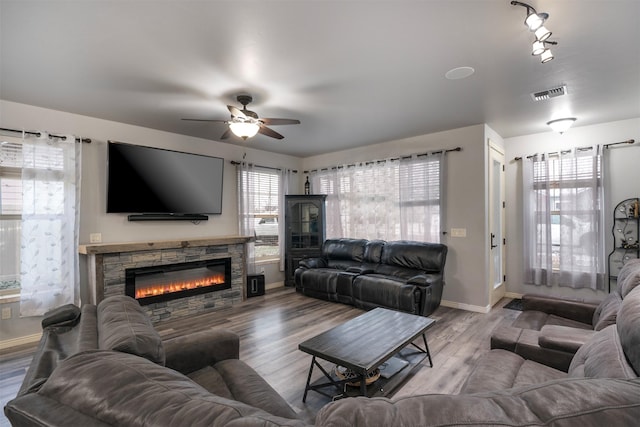 126 Moes Run, Kalispell, MT 59901 - living room featuring baseboards, ceiling fan, a stone fireplace, and visible vents