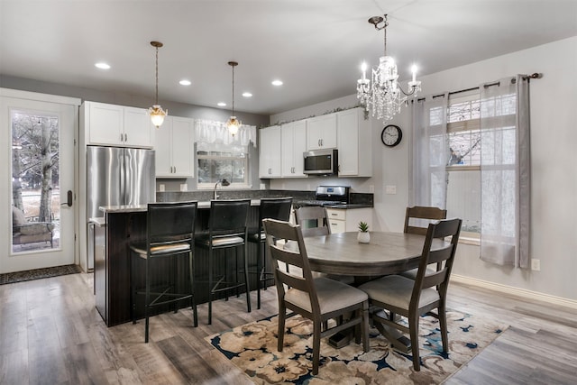 126 Moes Run, Kalispell, MT 59901 - dining space with plenty of natural light, recessed lighting, light wood-style floors, and an inviting chandelier