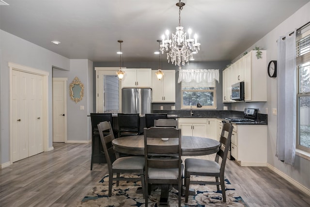 126 Moes Run, Kalispell, MT 59901 - dining room featuring baseboards, wood finished floors, and a notable chandelier