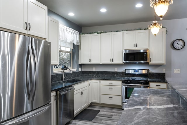 126 Moes Run, Kalispell, MT 59901 - kitchen featuring a sink, white cabinets, stainless steel appliances, and wood finished floors