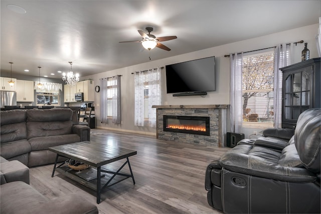 126 Moes Run, Kalispell, MT 59901 - living area with light wood-type flooring, baseboards, ceiling fan with notable chandelier, and a fireplace