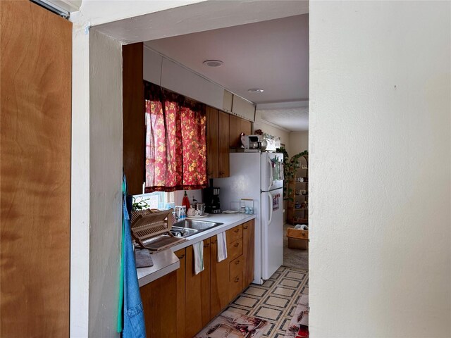 kitchen with sink and white fridge