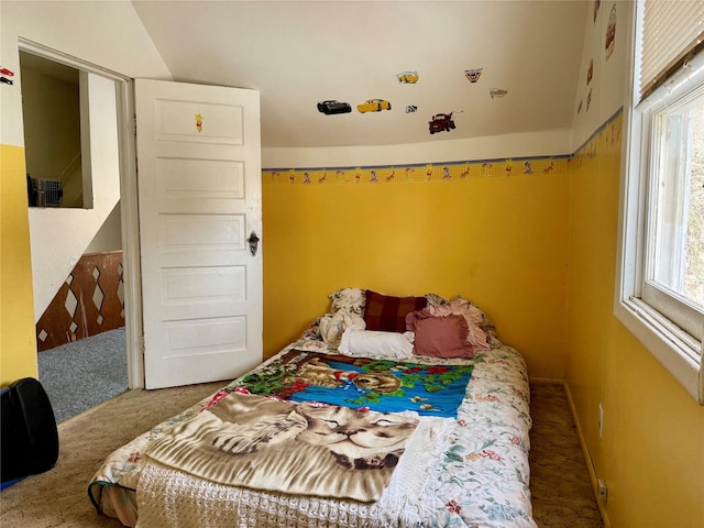 bedroom featuring carpet flooring, lofted ceiling, and multiple windows