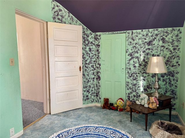 interior space featuring carpet floors and vaulted ceiling