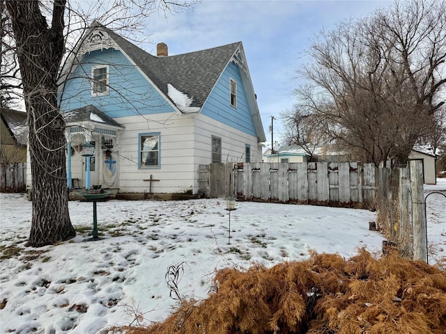 view of snow covered back of property