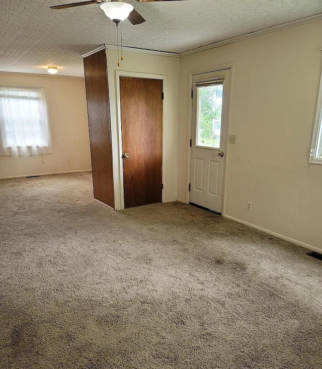 interior space featuring ceiling fan, crown molding, and a textured ceiling