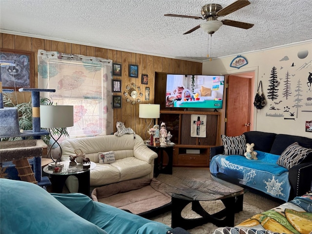 carpeted living room with ornamental molding, a textured ceiling, ceiling fan, and wooden walls