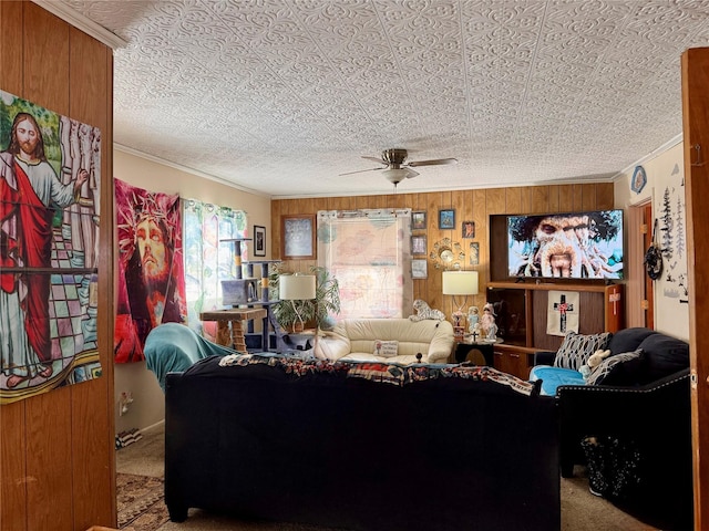 living room with carpet, ceiling fan, crown molding, and wooden walls