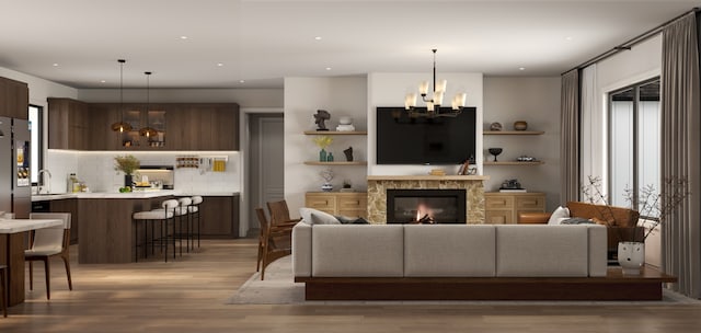 living room featuring a notable chandelier, light hardwood / wood-style floors, and sink