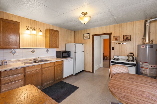 kitchen featuring sink, gas water heater, tasteful backsplash, wood walls, and white appliances