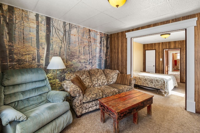 carpeted living room with wooden walls