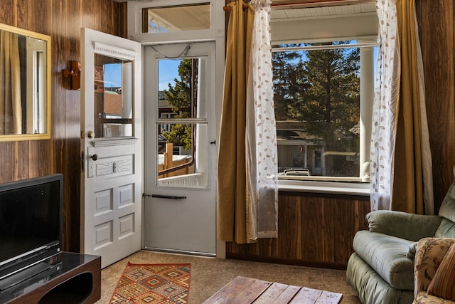 doorway to outside with wooden walls