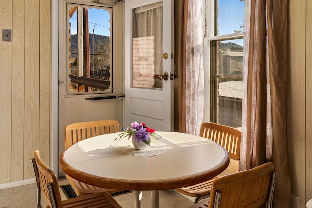 dining space featuring wood walls