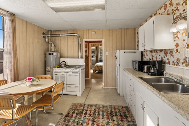 kitchen with a paneled ceiling, white cabinets, gas water heater, sink, and white range with gas cooktop