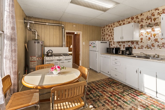 kitchen featuring a drop ceiling, sink, gas water heater, white appliances, and white cabinets