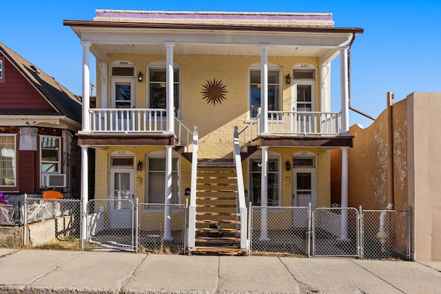 view of front of house featuring a balcony, cooling unit, and a porch