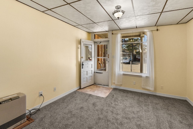 spare room featuring carpet and a paneled ceiling