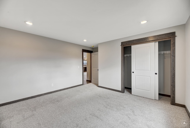 unfurnished bedroom featuring a closet and light colored carpet