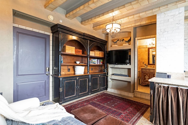 living room featuring beamed ceiling, built in shelves, and a chandelier