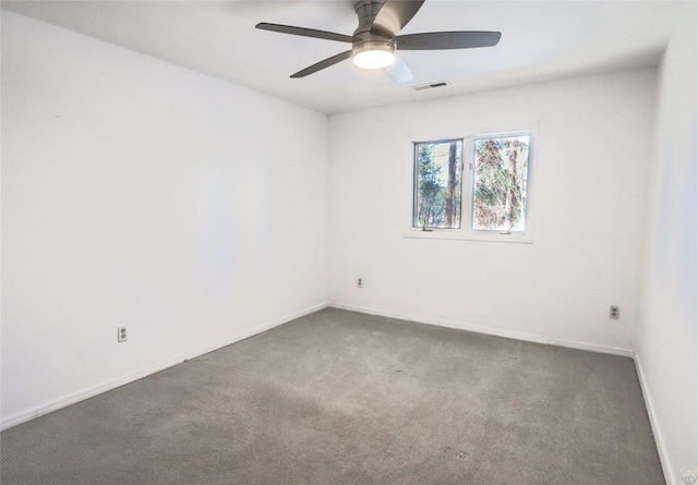 spare room with ceiling fan, carpet floors, visible vents, and baseboards