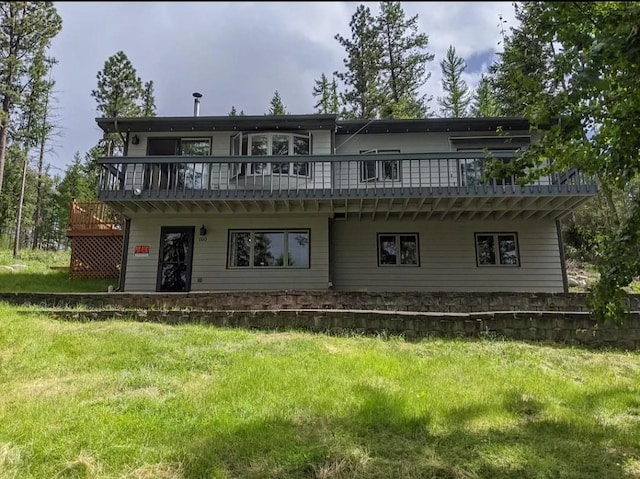 rear view of house with a yard and a deck