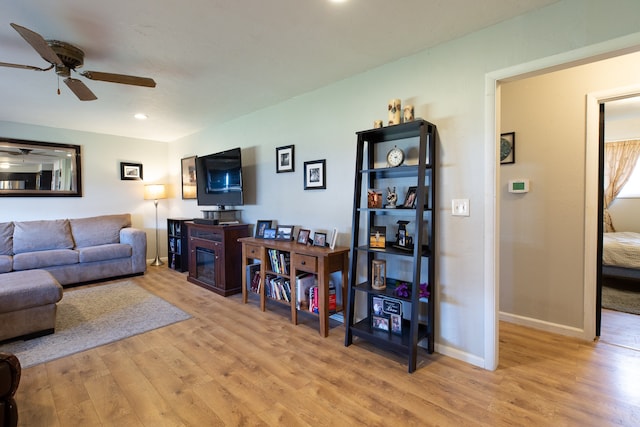 living room with ceiling fan and light hardwood / wood-style floors