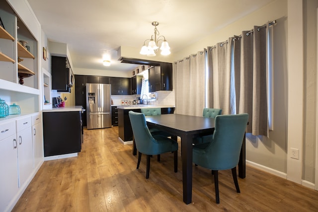 dining area featuring light hardwood / wood-style floors, sink, and a chandelier