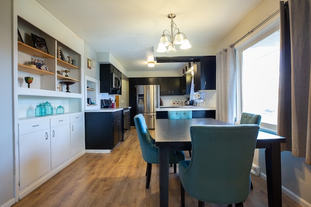 dining area featuring an inviting chandelier and light hardwood / wood-style flooring