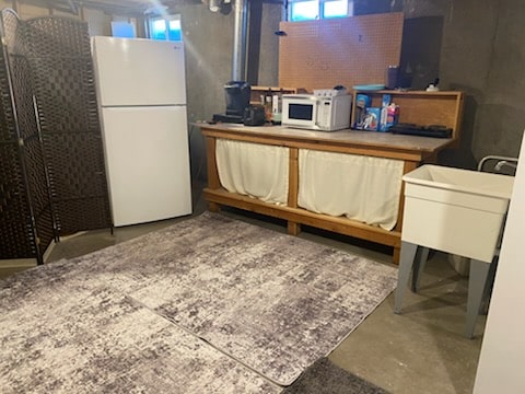 kitchen with white appliances and concrete flooring