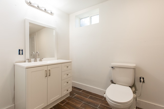 bathroom with wood-type flooring, vanity, and toilet