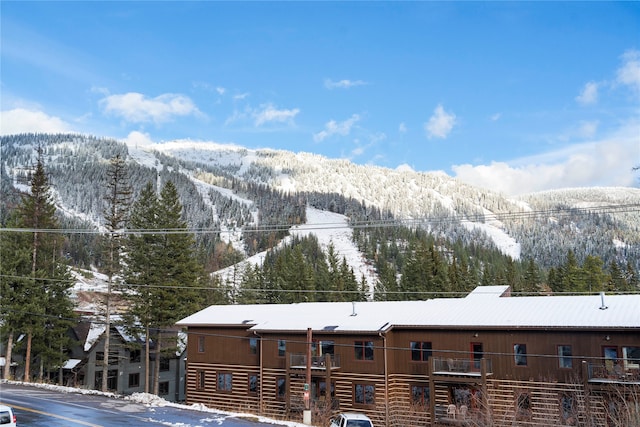 snow covered building featuring a mountain view